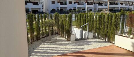 A modern multi-story residential building with balconies and a gated courtyard.