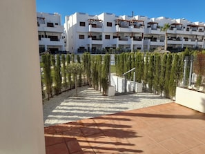 Stylish building with balconies and windows, set amidst a beautifully maintained garden.