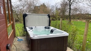 A hot tub on a wooden deck with a wooden house in the background. - Lilac Lodge Retreat for 6, Set in One Acre of Land (Otley)