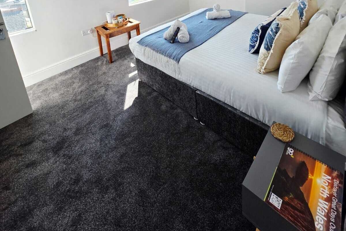 Ein Schlafzimmer mit einem Bett, einem Fernseher, einem kleinen Tisch und einem Fenster.