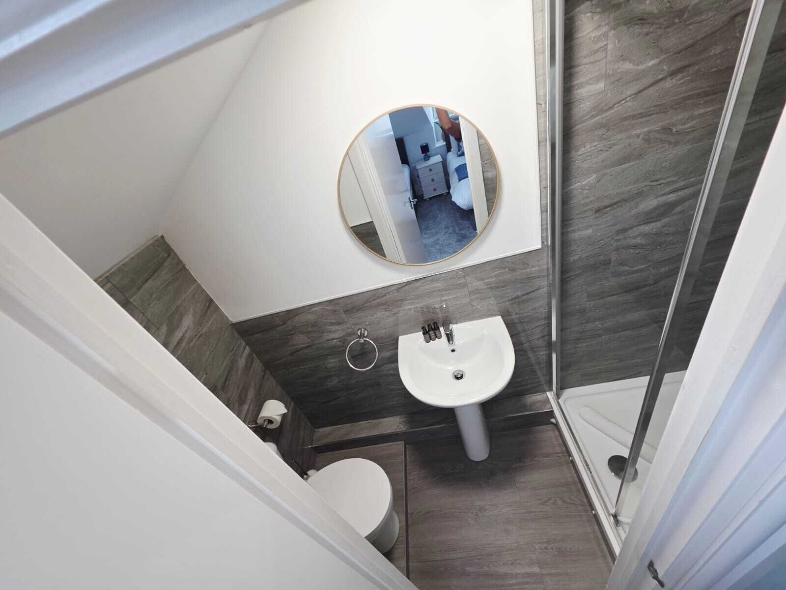 Un baño pequeño con un lavabo blanco, un inodoro y un espejo.