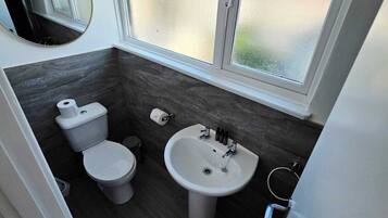 A modern bathroom with a toilet, bidet, and sink.