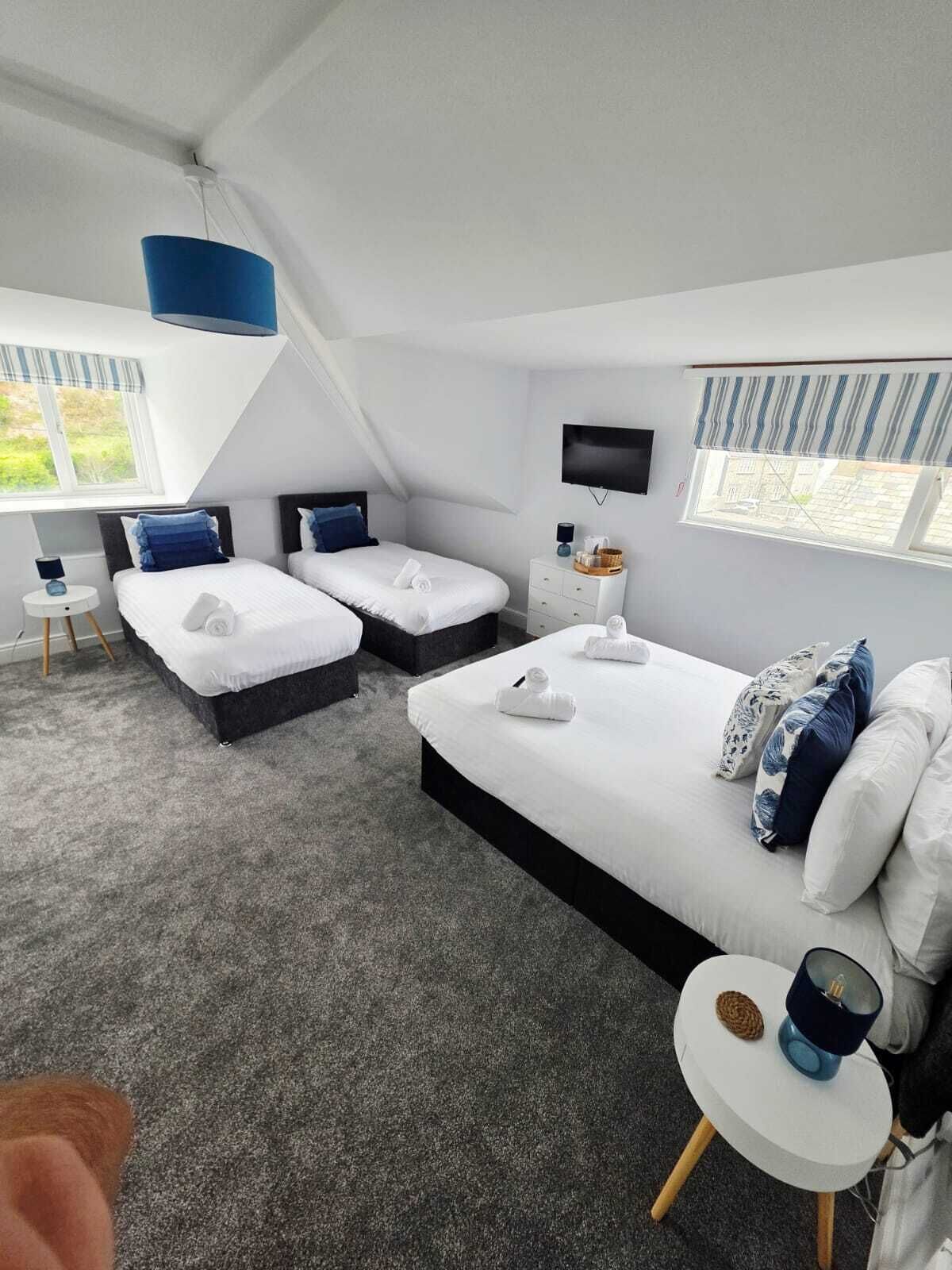 Een moderne hotelkamer met twee bedden, een flatscreen-tv, een klein tafeltje en een raam met uitzicht.