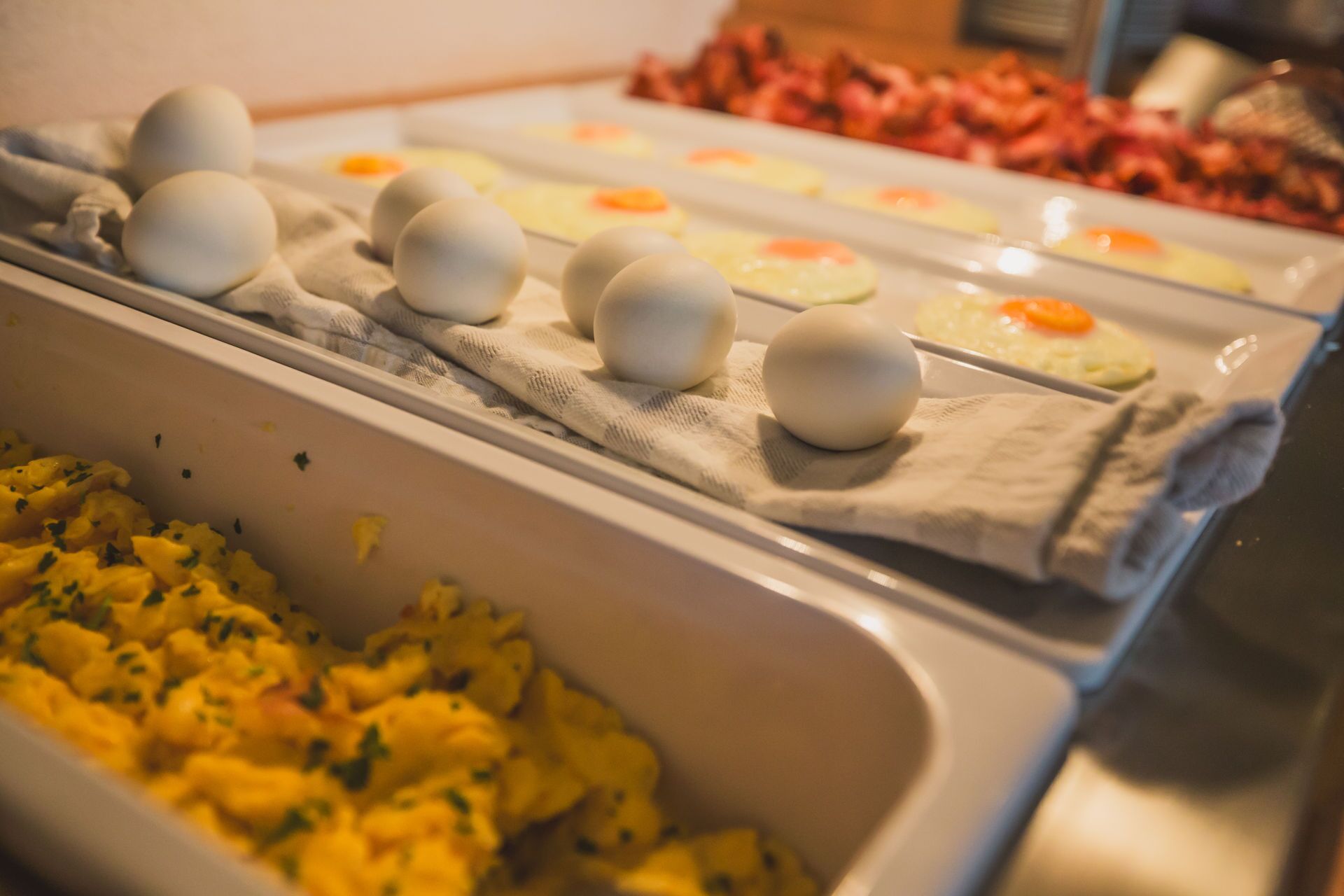 A buffet with various food items including eggs, scrambled eggs, and other dishes.