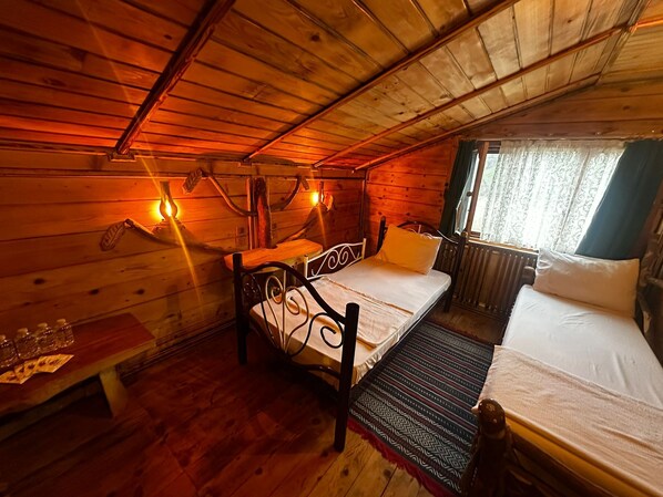 Acogedora habitación tipo cabaña de madera con cama, una mesita y un banco.