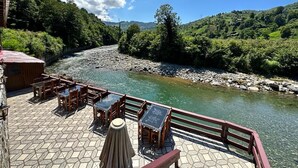 A riverside patio with outdoor seating and a view of the river. - Rubaşi Butik Otel & Restoran (Findikli)