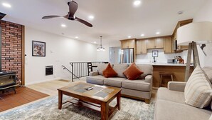 A modern living room with a sofa, coffee table, and a fireplace.