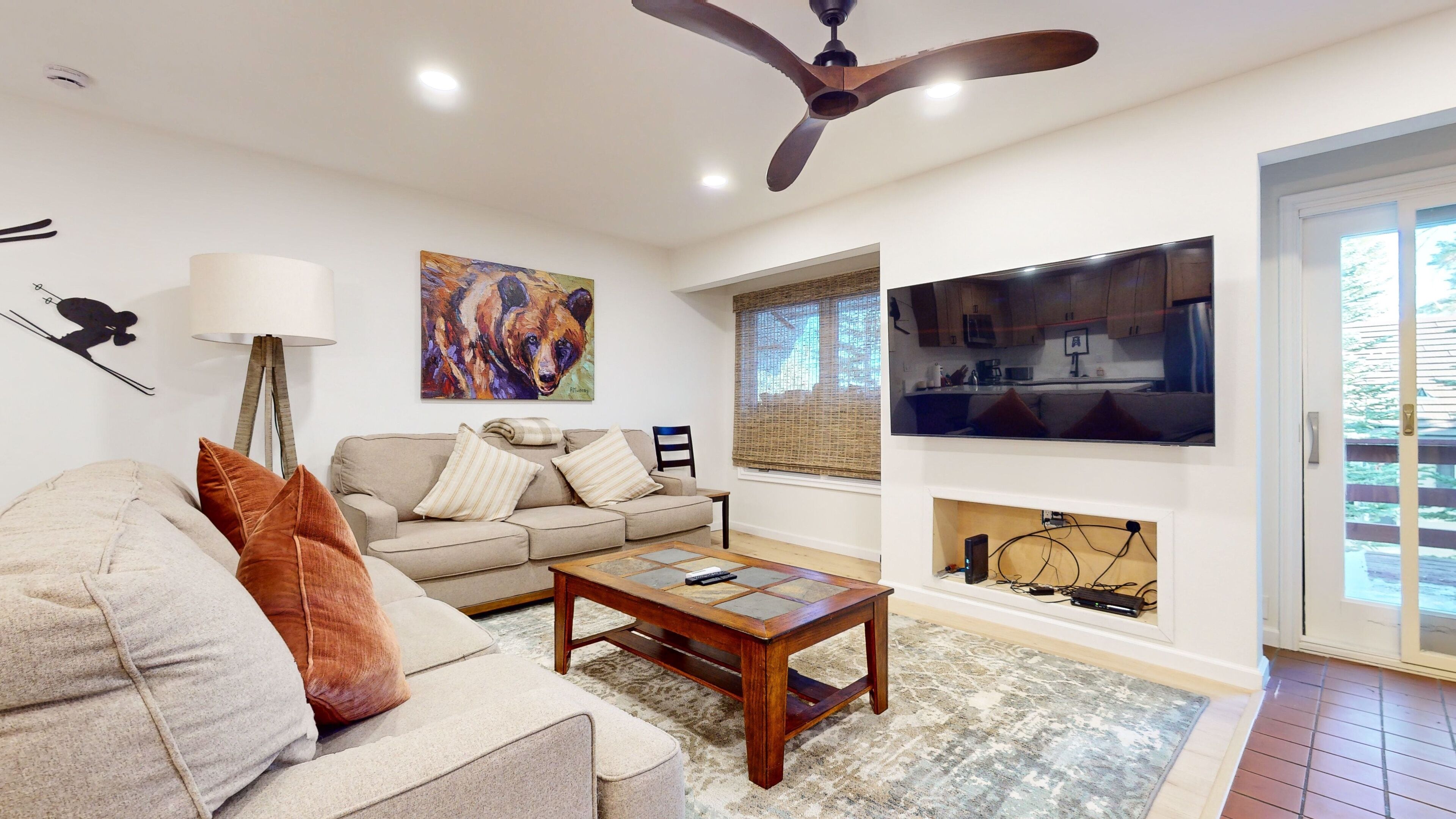 A living room with a sofa, coffee table, and artwork.