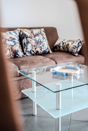 Relax in this stylish living room with a glass coffee table and comfortable sofa.