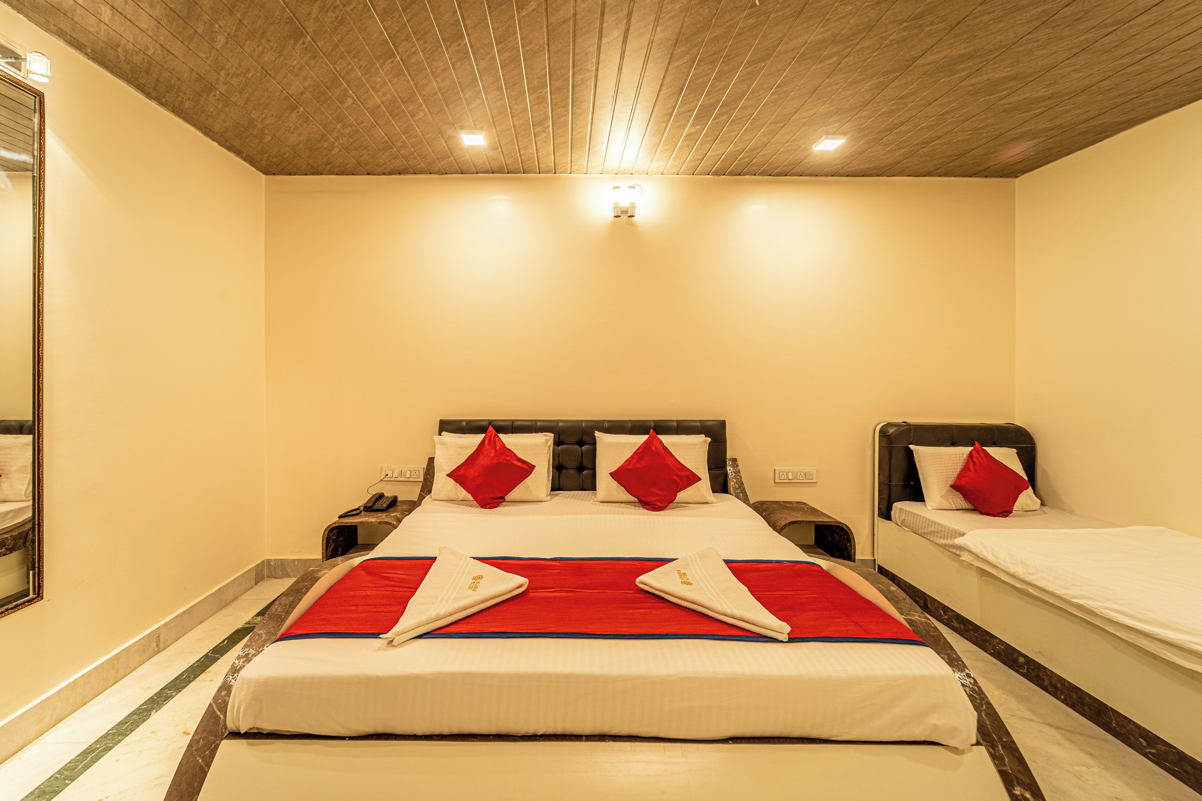 Ein Hotelzimmer mit einem großen Bett, zwei Nachttischen und einer Decke mit Einbauleuchten.