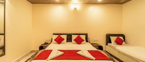 Ein Hotelzimmer mit einem großen Bett, zwei Nachttischen und einer Decke mit Einbauleuchten.