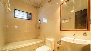A bathroom with a bathtub, toilet, and sink. - Seasons Suites HBR (Bengaluru)
