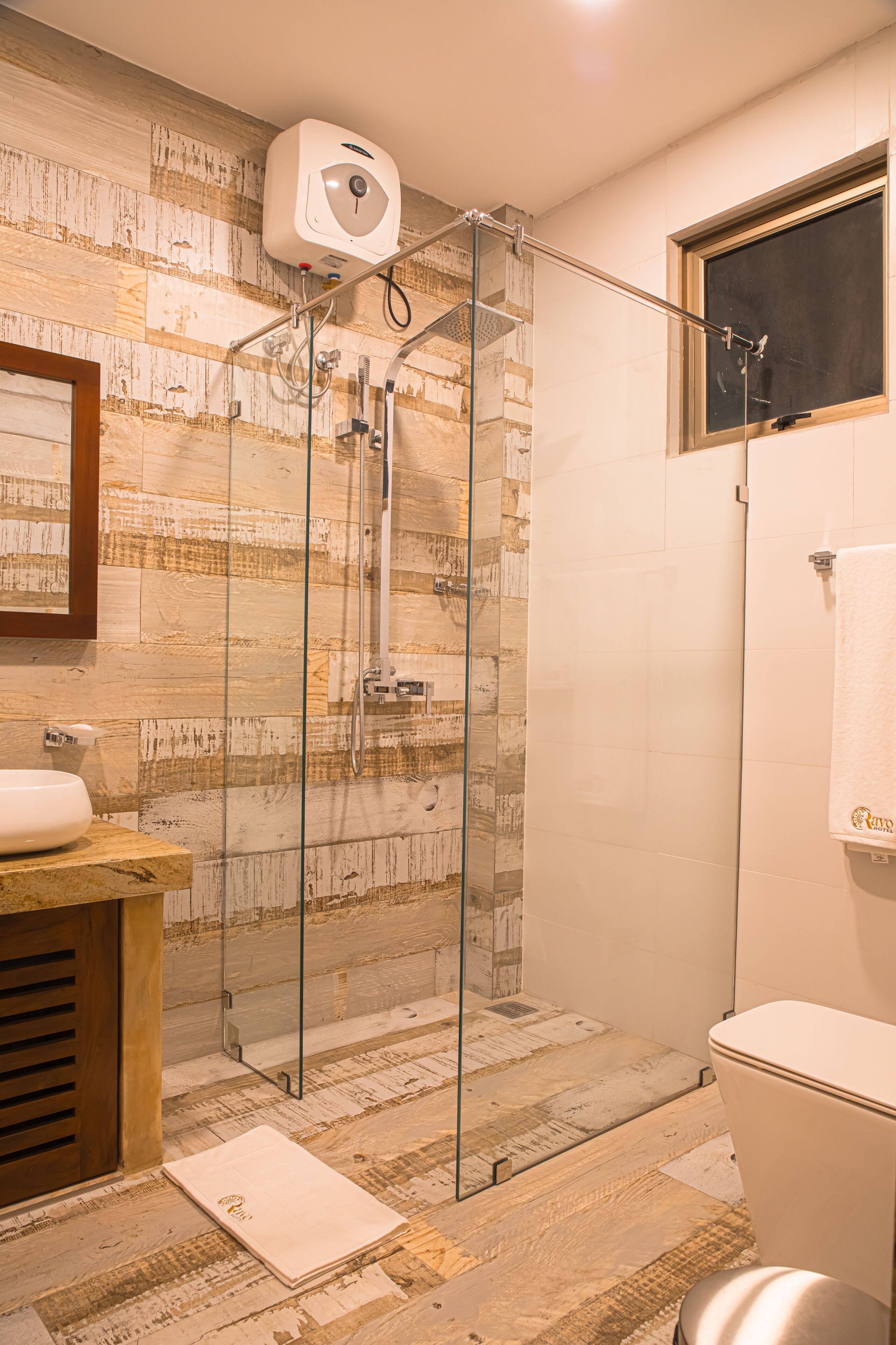 A bathroom with a glass-enclosed shower, a wooden vanity, and a toilet.