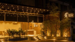 A hotel exterior with a modern design, featuring a brick facade, outdoor seating area, and a well-lit entrance. - Ravo Hotel (Galle)