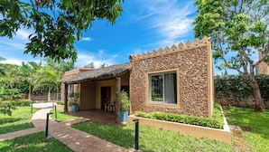 A small, single-story building with a stone facade and a thatched roof. - Babylon Gardens (Diani Beach)