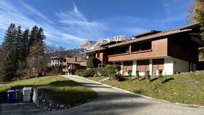 A modern two-story house with a sloped roof, a stone retaining wall, and a paved driveway. - Casa Funivia, Casa Funivia, close to the center and the cableway (Cortina d´Ampezzo)