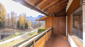 A wooden balcony with a view of a mountainous landscape and a road. - Casa Funivia, Casa Funivia, close to the center and the cableway (Cortina d´Ampezzo)