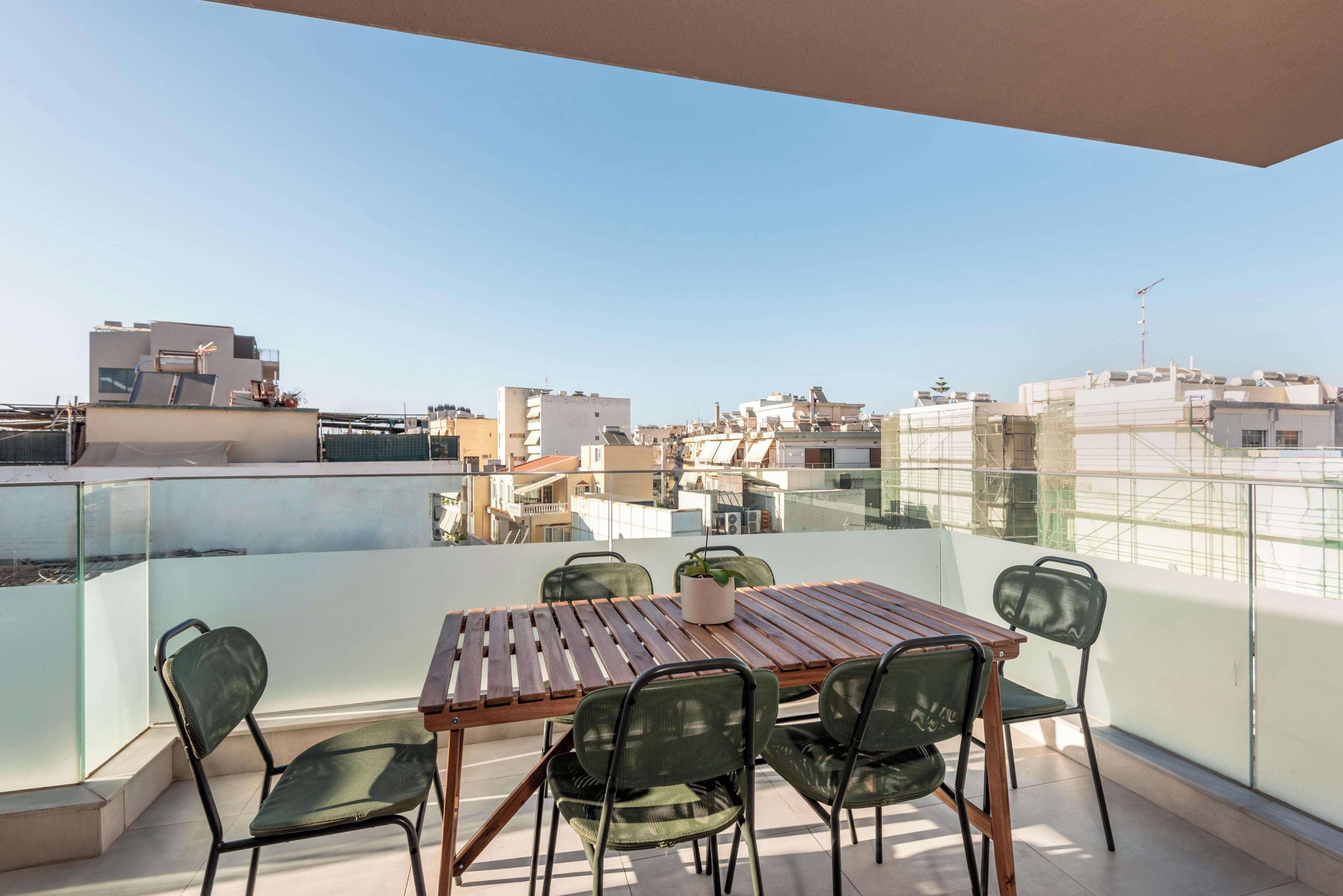 Un balcone con tavolo e sedie, vista sulla città.
