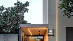 A modern building entrance with a sign reading "HARMA CITY LIVING" and the number "28". - Harma City Living (Chania)