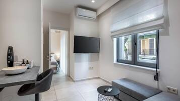 Apartamento econômico, vista para a cidade, no piso térreo | Área de estar | Smart TV 42 polegadas com canais a cabo, escritórios