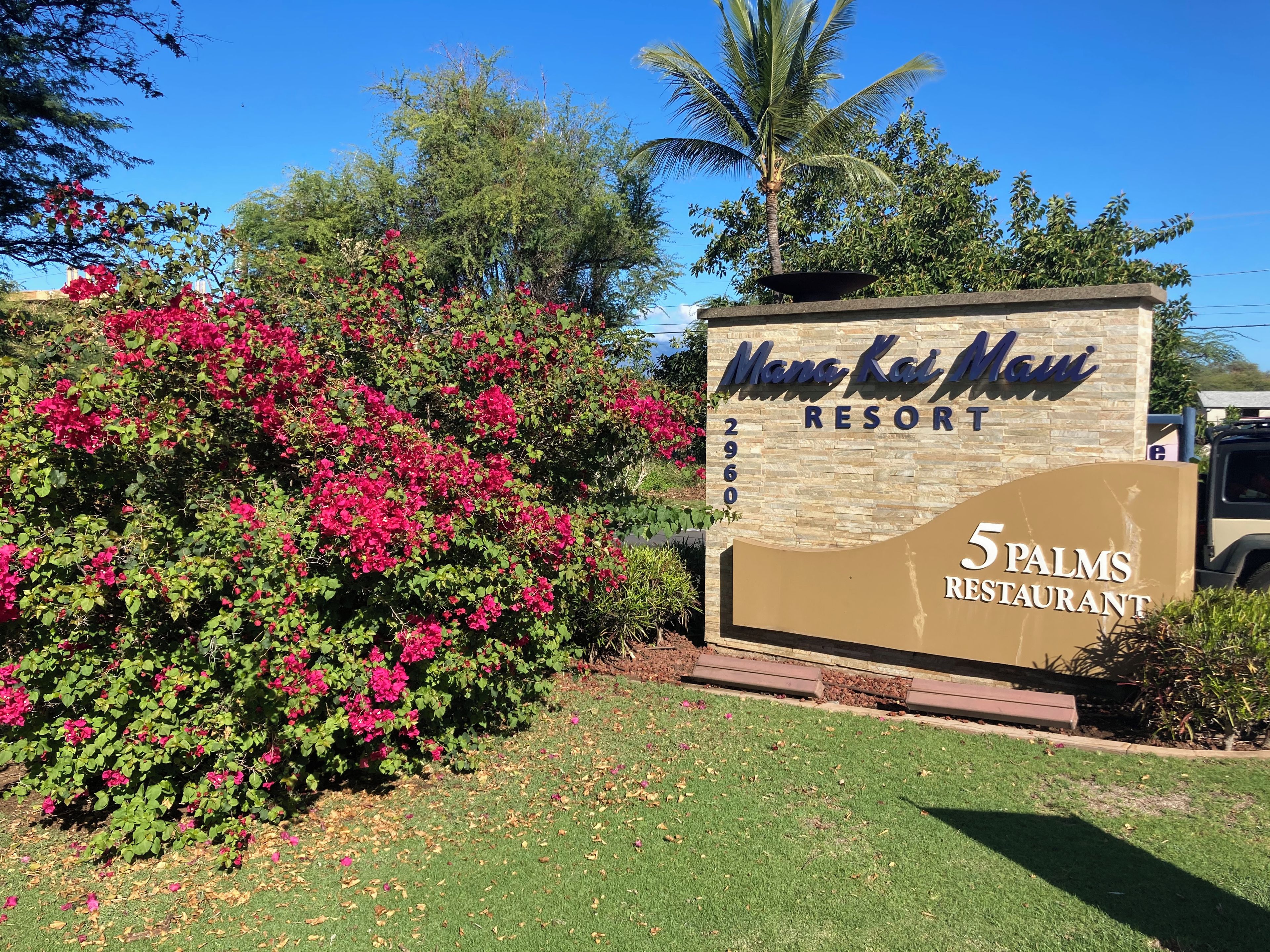 A sign for Mana Kai Mai Resort with a 5 Palms Restaurant.