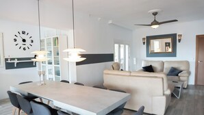 A modern living room with a dining area, a sofa, and a ceiling fan. - Villa Padel (Alhaurin de la Torre)