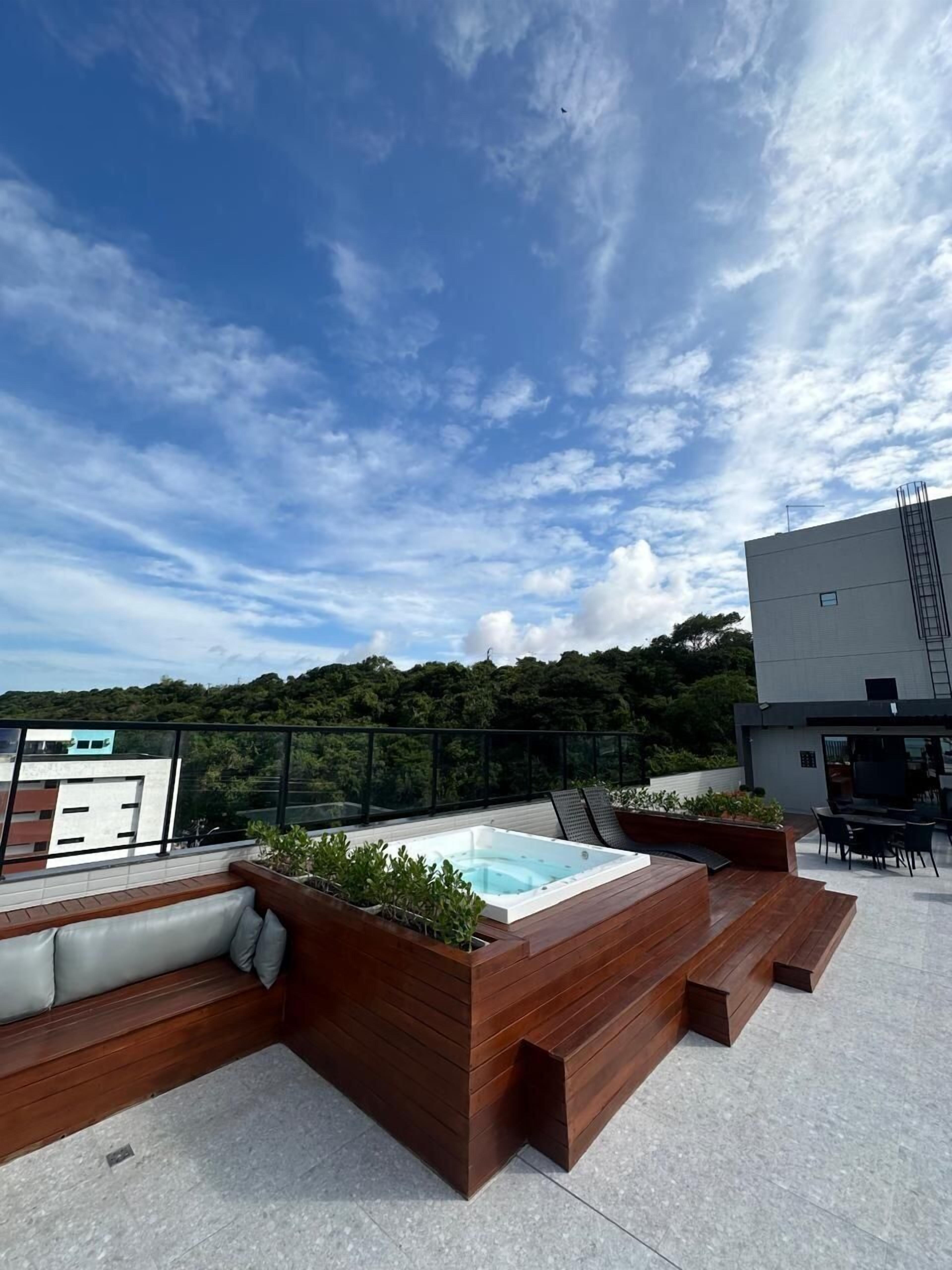 Una terraza en la azotea con hidromasaje, zona de estar y vistas del paisaje circundante.