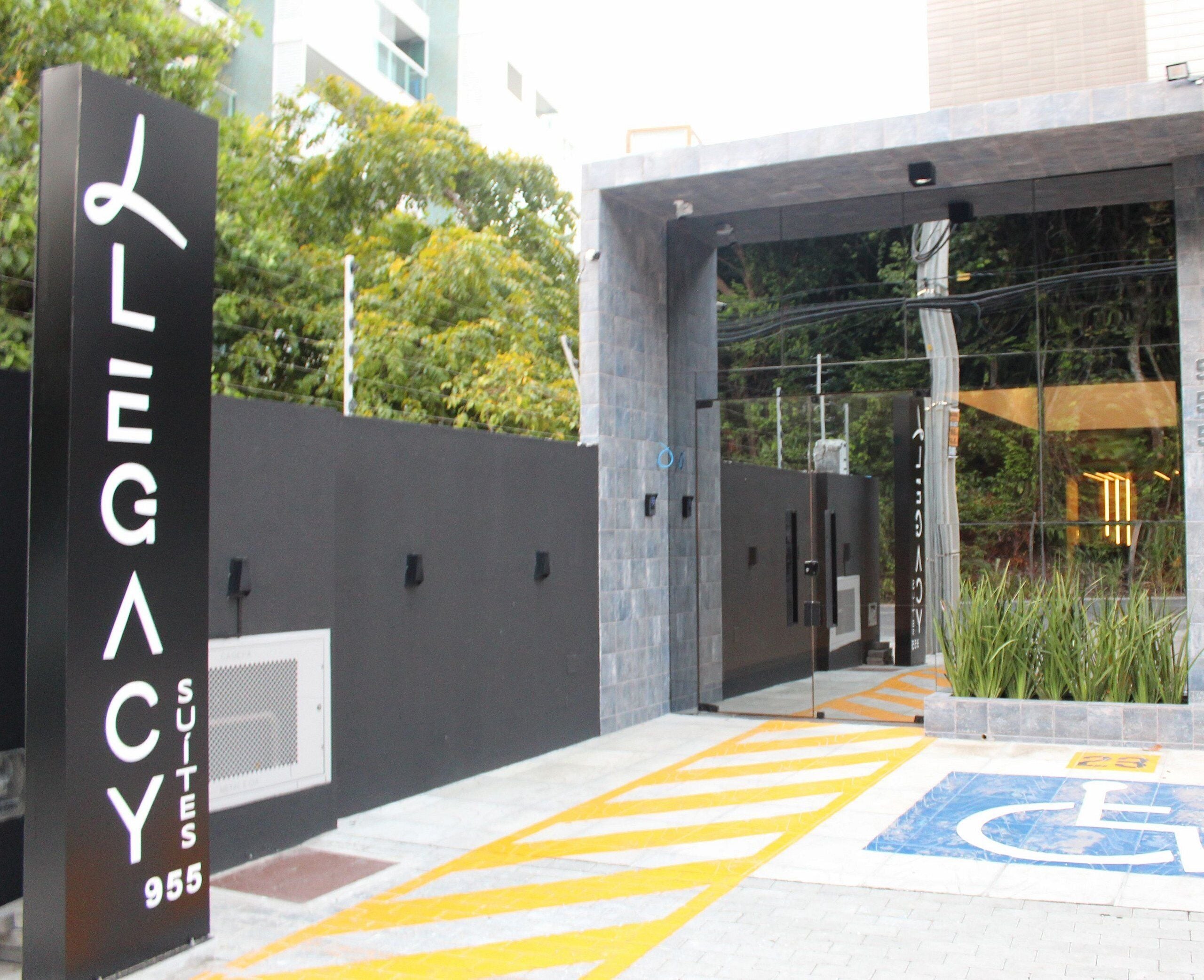 A hotel entrance with a sign reading "Legacy Suites 955".