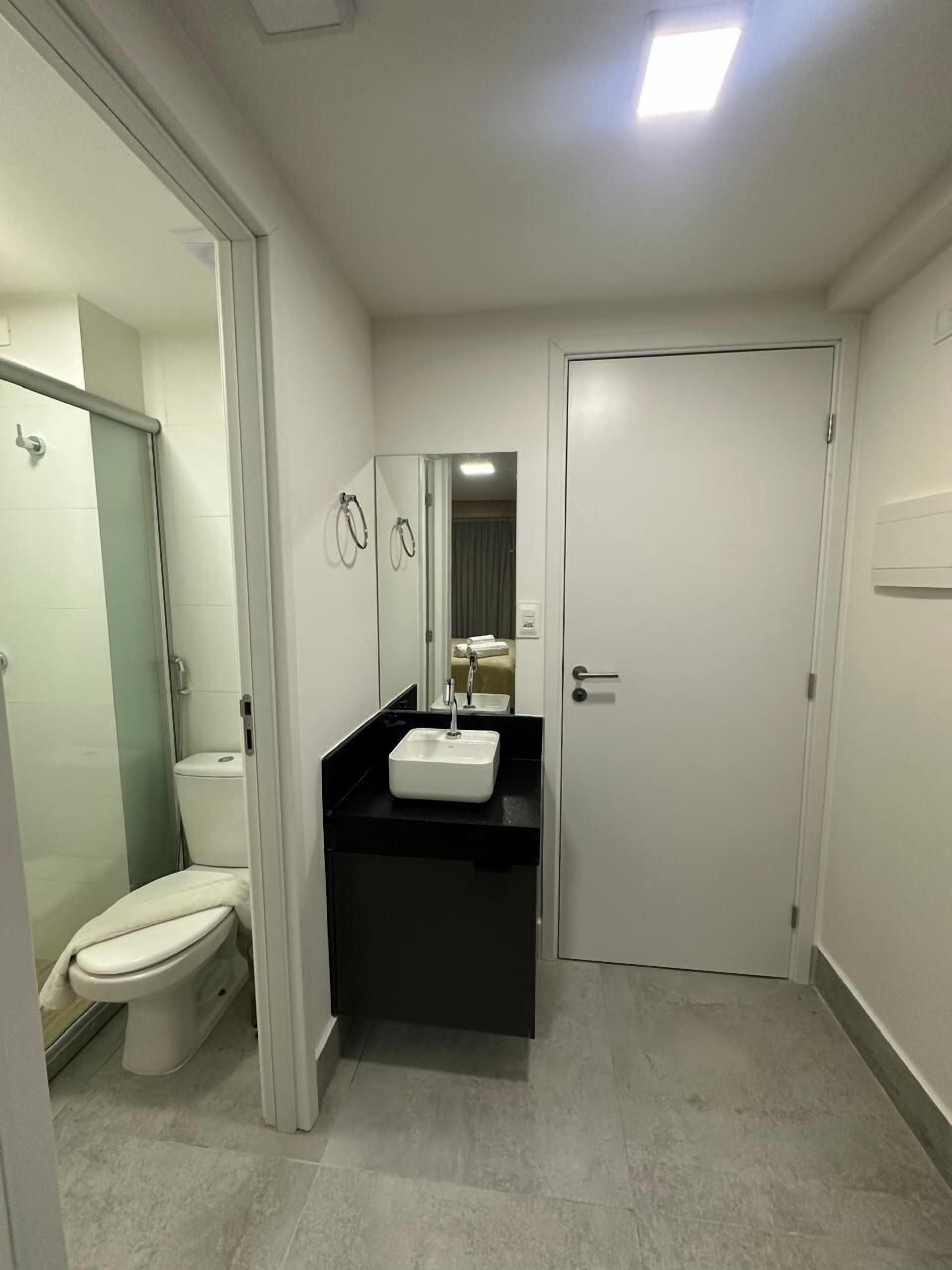Un baño moderno con inodoro, lavabo y ducha.