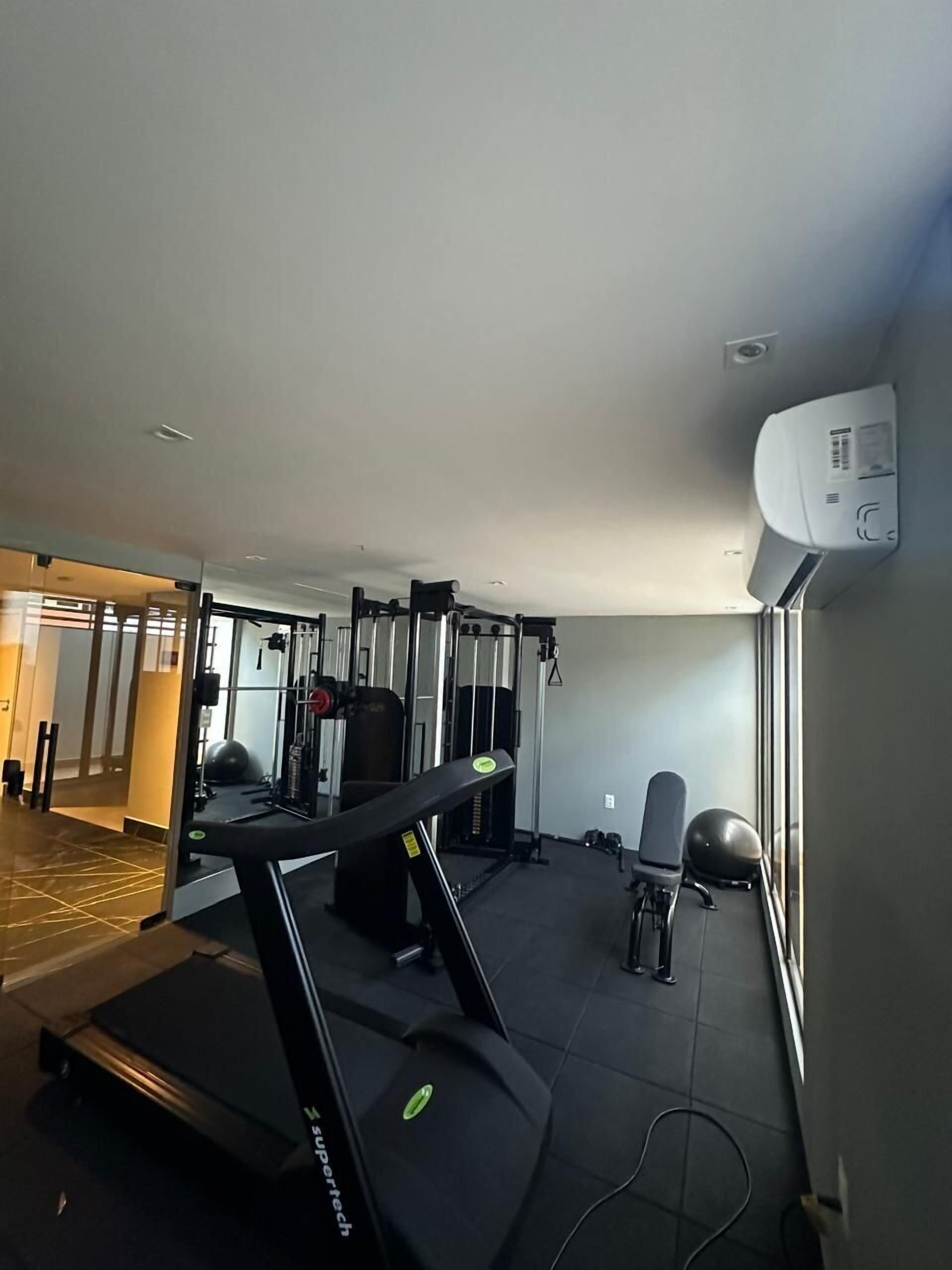 A gym with treadmills, weight machines, and exercise balls.