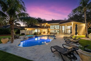 A two-story house with a swimming pool, outdoor seating, and a well-maintained garden. - Luxurious 6-Bedroom Villa with Pool & Games (Parkland)