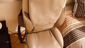 A beige office chair with a visible brand name "HOMEDICS" on the backrest.