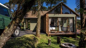 A rustic cabin with a glass-enclosed bedroom, a stone exterior, and a surrounding natural landscape. - Bulawayo Lodge (Urubici)