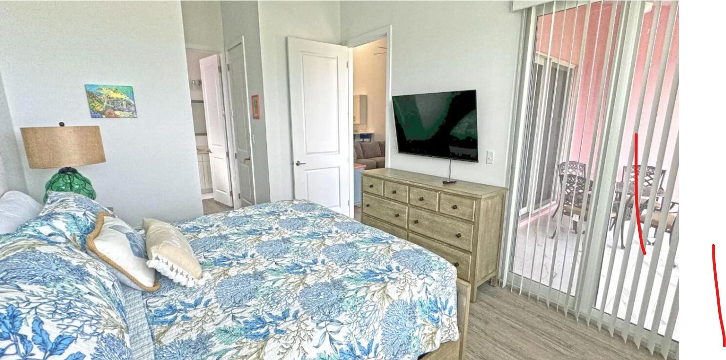 A bedroom with a bed, dresser, TV, and a sliding door.