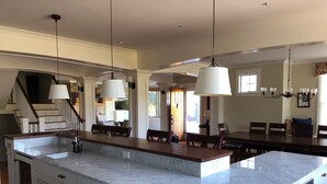 A spacious kitchen with a large island, white cabinetry, and pendant lighting. - Spacious 5-bedroom estate with access to private beach in peaceful Falmouth (Falmouth)