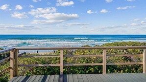 A wooden deck overlooking a beach with ocean waves and a clear sky. - Falcon Getaway - New Oceanfront Listing! (Arch Cape)