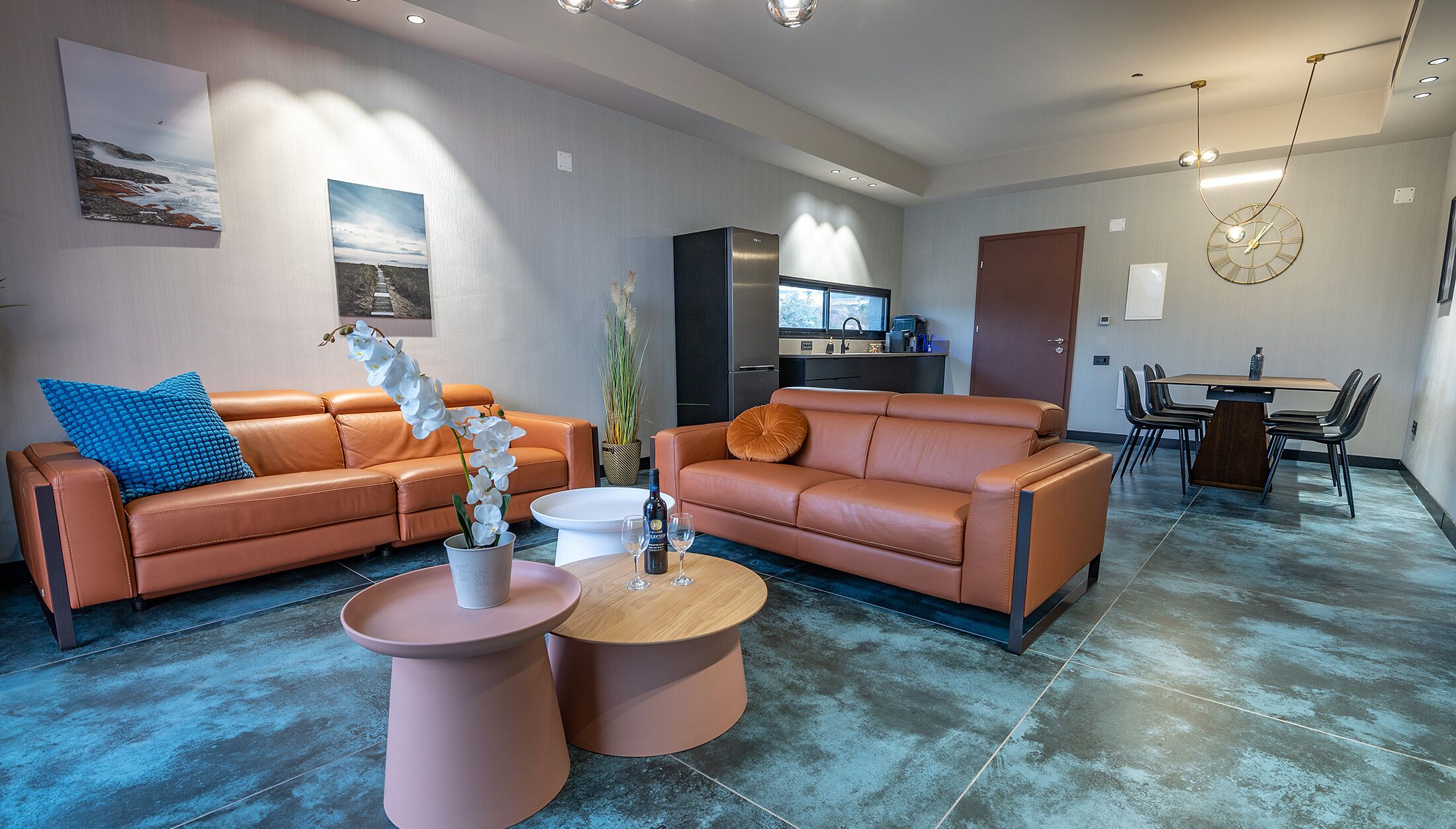 Un salon moderne avec deux canapés en cuir, une table basse et un coin repas comprenant une table et des chaises.