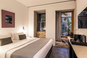 Une chambre d’hôtel moderne dotée d’un grand lit, d’une petite kitchenette et offrant une vue sur l’extérieur.