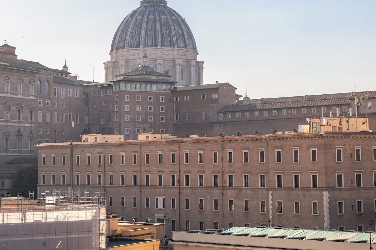 A large building with a prominent dome and a series of smaller buildings in the foreground.