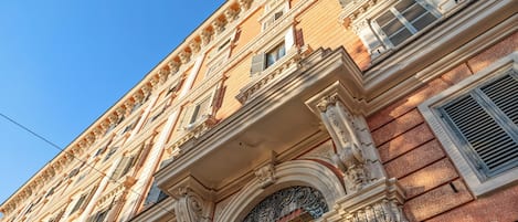 Ein mehrgeschossiges Gebäude mit aufwendigen architektonischen Details, darunter Säulen und dekorative Stuckleisten.