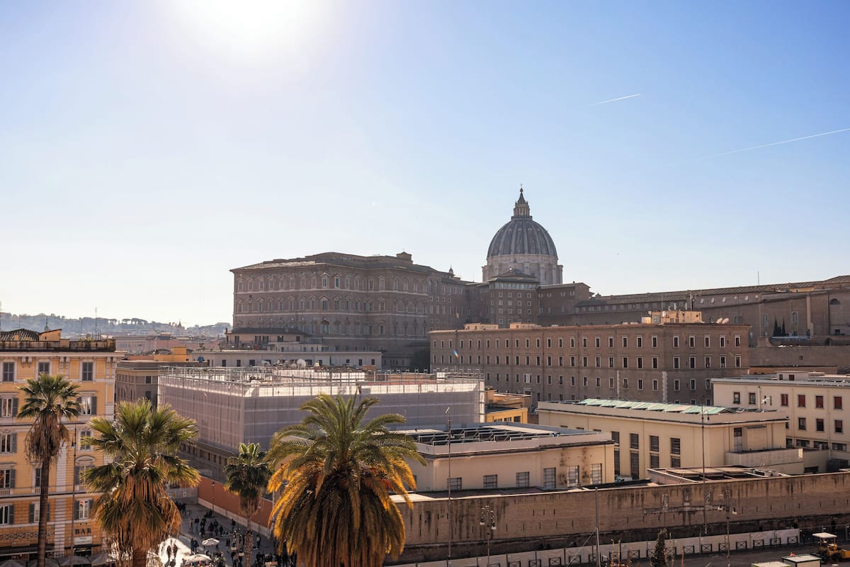 A cityscape with a prominent dome building and palm trees.