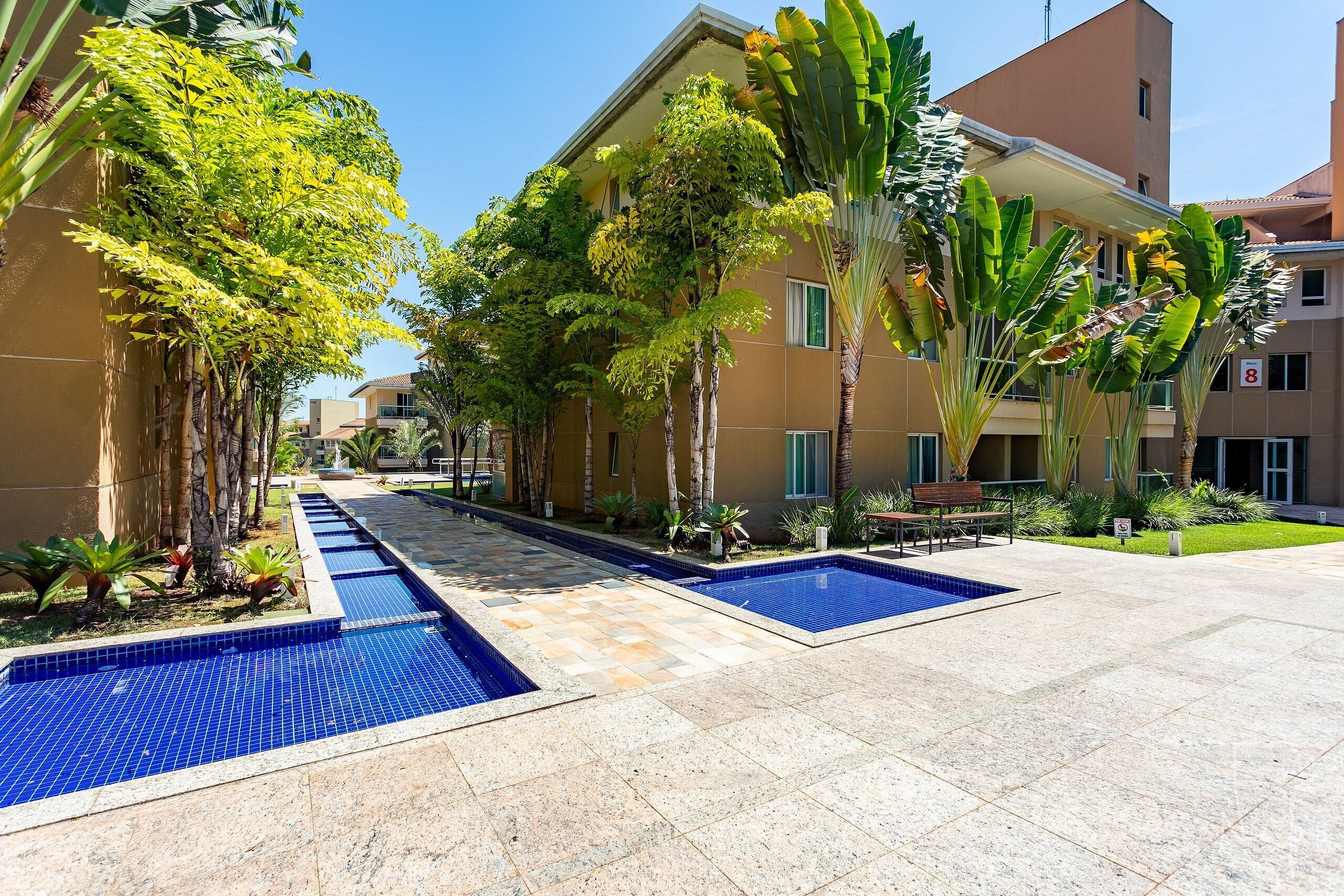 A pool area with tiled flooring and a clear blue sky.