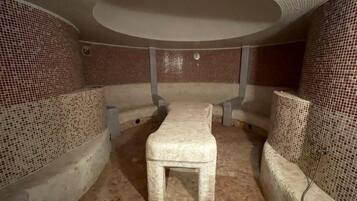 Relax in a serene space with a central bench and two side benches, surrounded by a mosaic tile design.