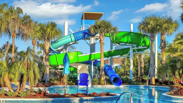 A water park with multiple slides and a pool area surrounded by palm trees.