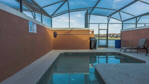 An indoor swimming pool with clear glass walls, a bench, and a view of the outdoors. - 4BR house with pool near Disney area (Kissimmee)
