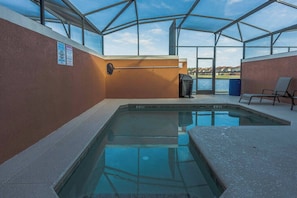 En inomhuspool med väggar av genomskinligt glas, en bänk och utsikt över omgivningen.