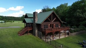 A log cabin with a stone chimney, a wooden deck, and a staircase leading to a second-story balcony. - A Slice of Salisbury, Pool,Hot Tub, 10 acres (Salisbury)