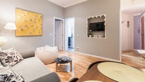 A modern living room with a sofa, coffee table, and a wall-mounted TV.