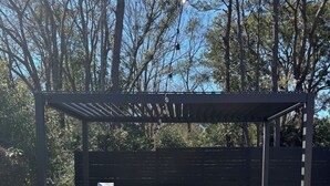 An outdoor patio with a grill, a sofa, and a table. - Charming 2-bedroom house in beautiful Charleston with full kitchen, AC, patio (Charleston)
