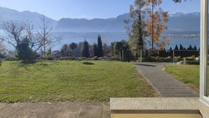 Een terras met uitzicht op een meer en bergen.